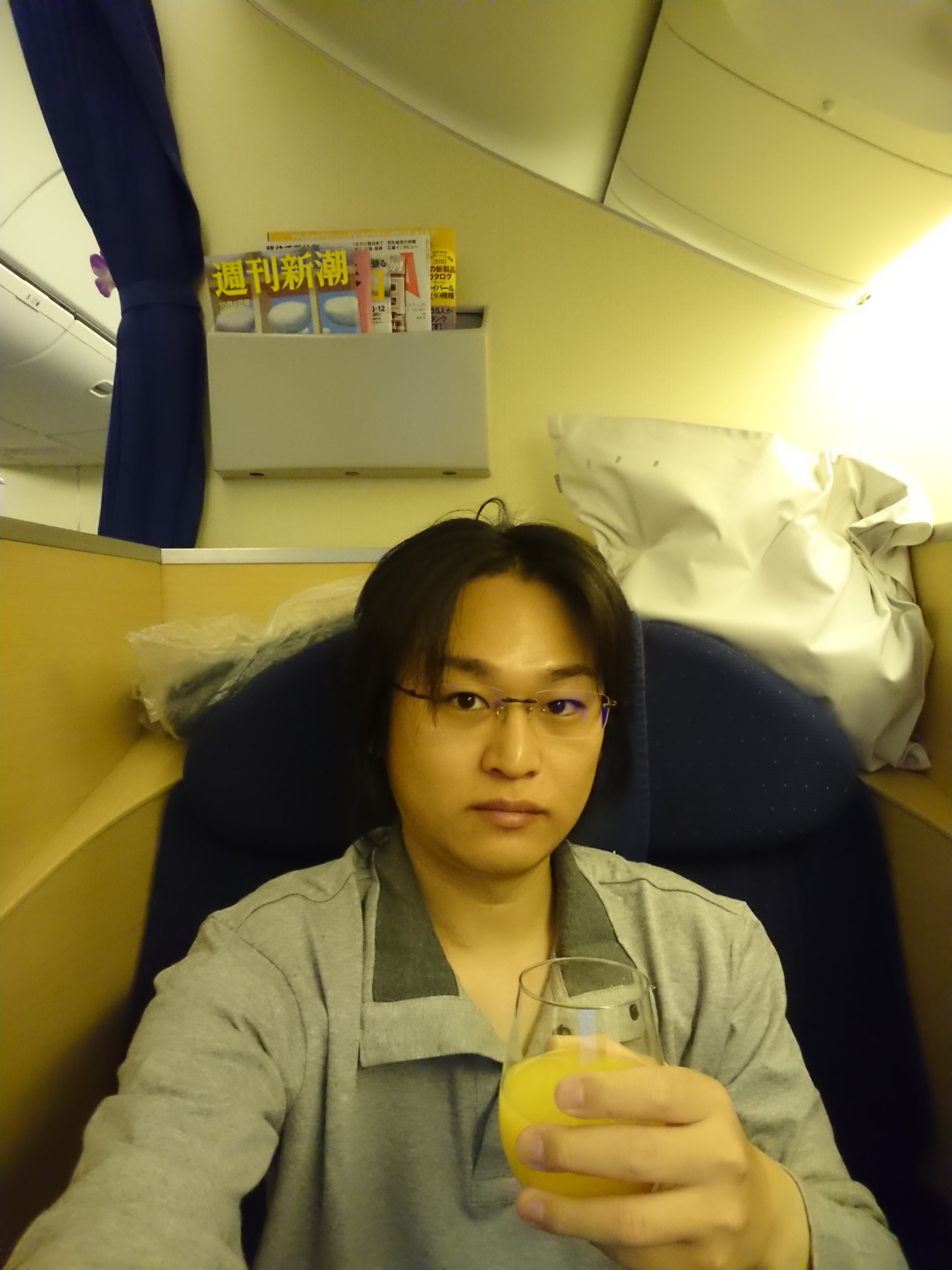 自撮りとオレンジジュースのコップ