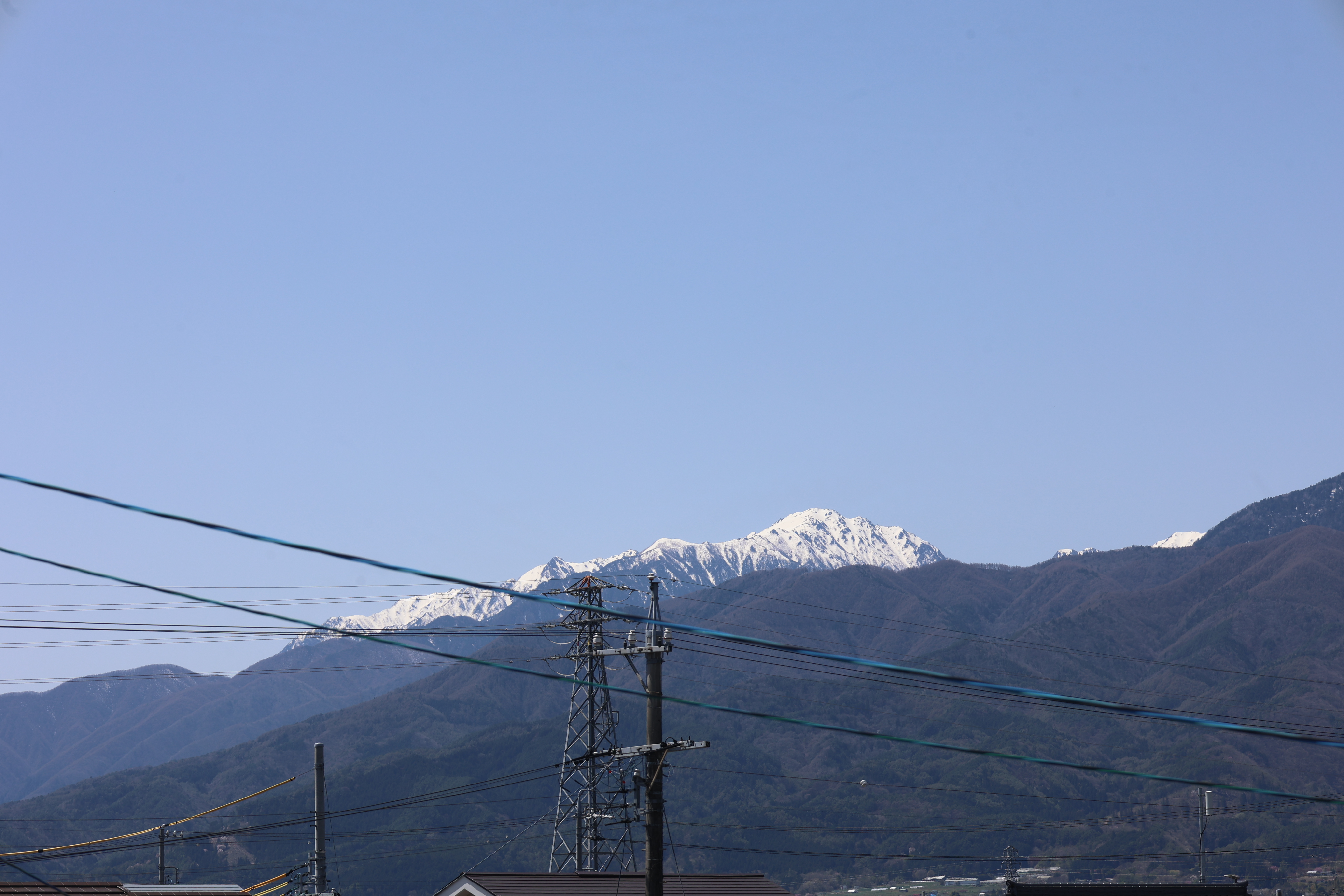 会議室から見た山の残雪と電力線２