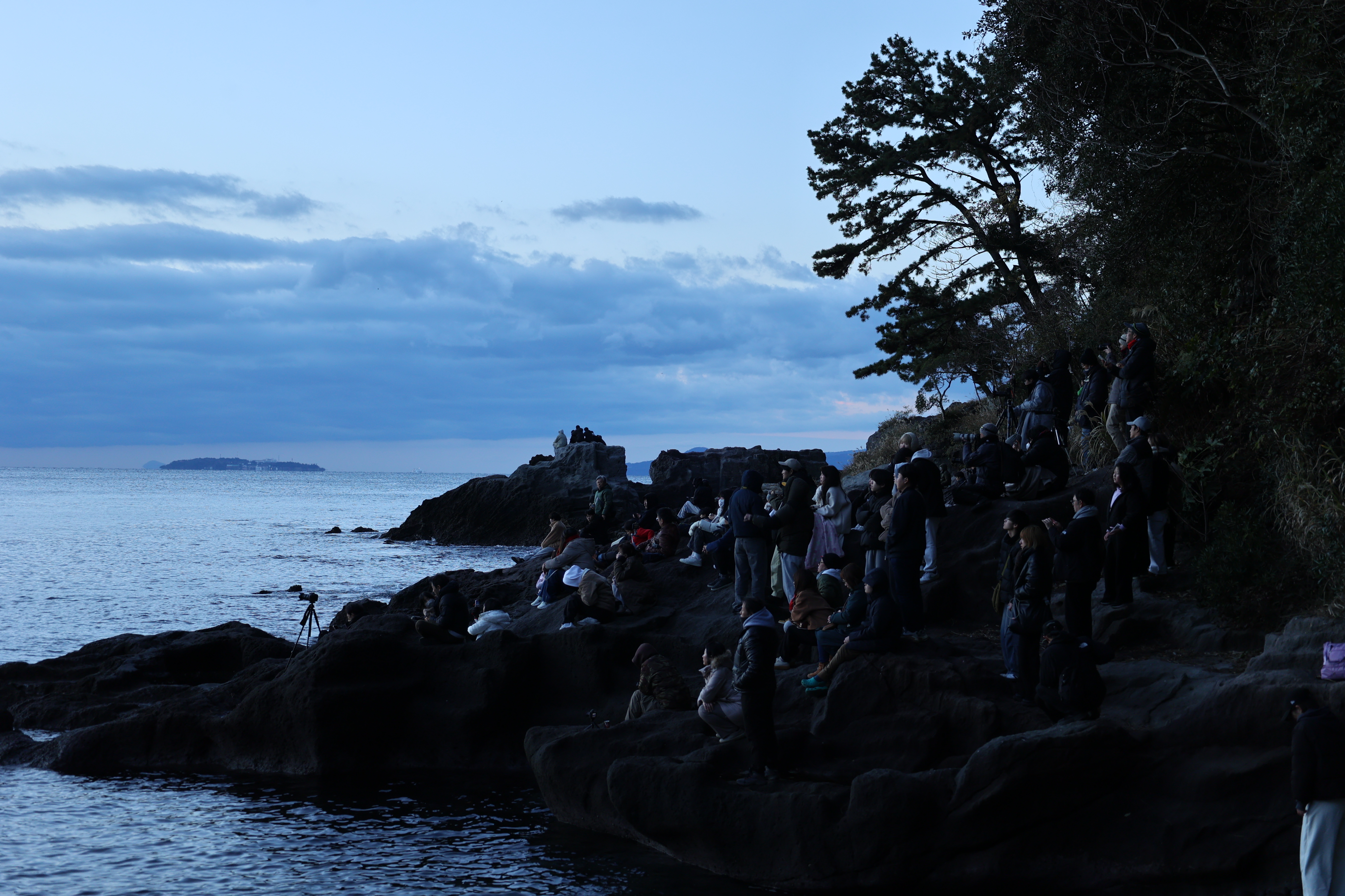 岩場でシャッターチャンスを待つ人たち
